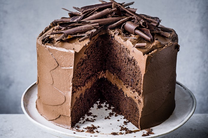 A large chocolate fudge cake on a white plate