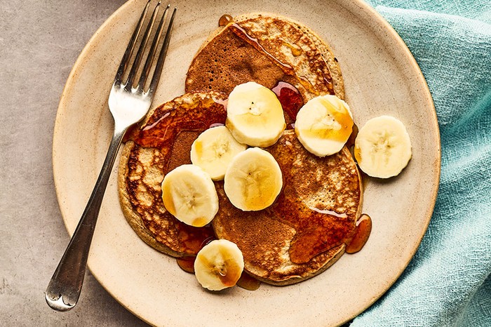 Plate of pancakes with syrup and bananas