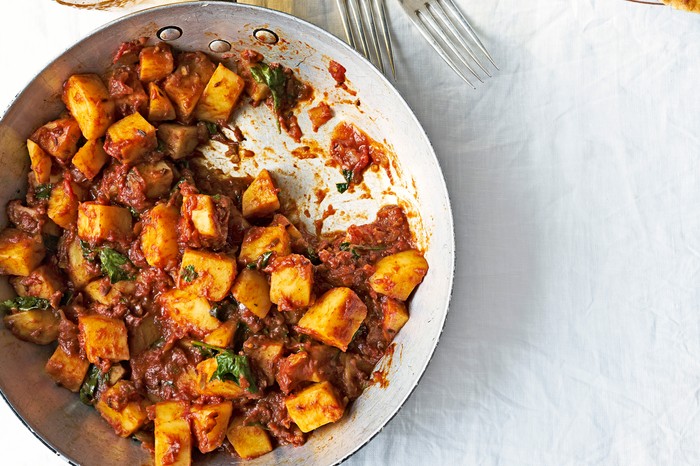 Potato Curry Recipe with tomatoes, coriander, chilli and ginger. With sides of rice, naan bread and cold beer