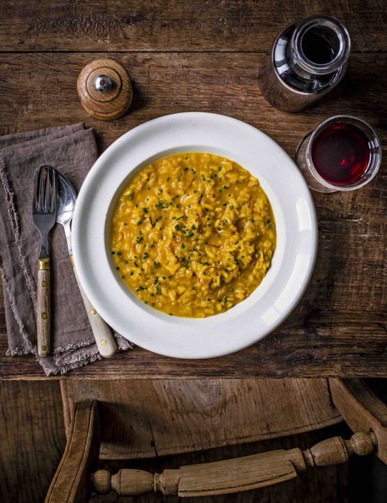 An aerial shot of saffron-coloured risotto on a white plate